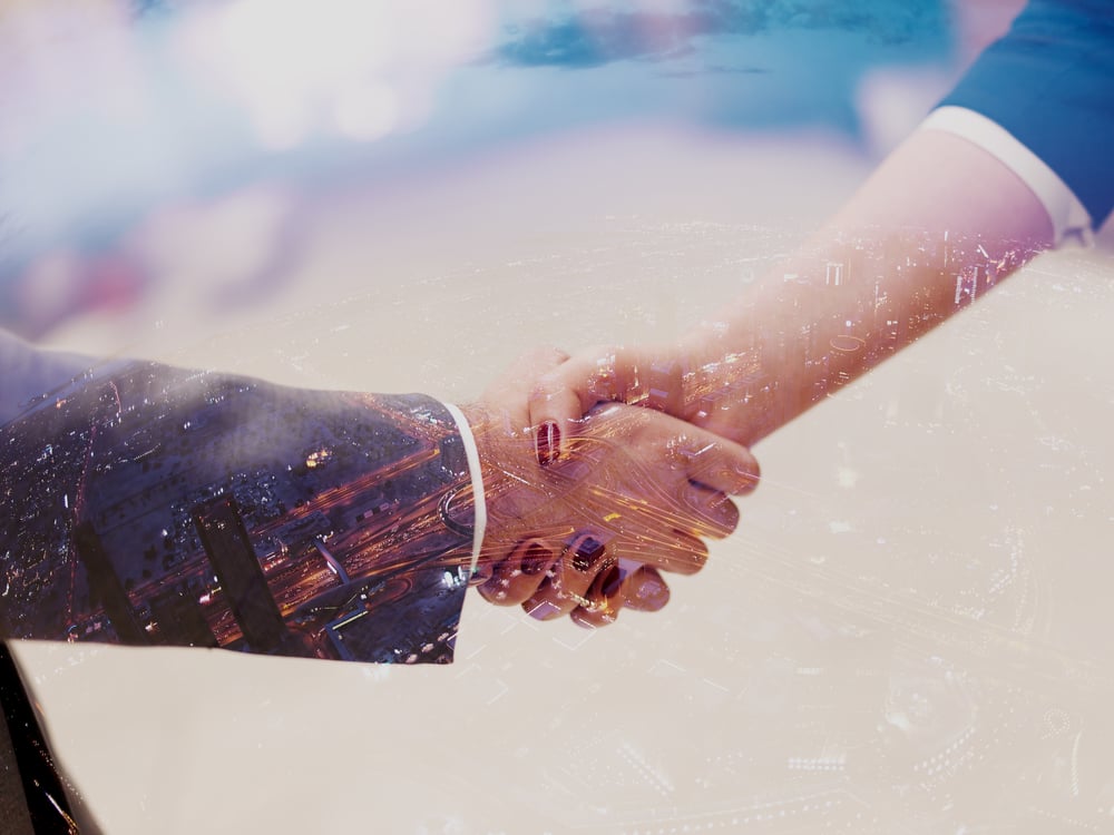 Double exposure design. Business partners concept with businessman and businesswoman handshake at modern office indoors